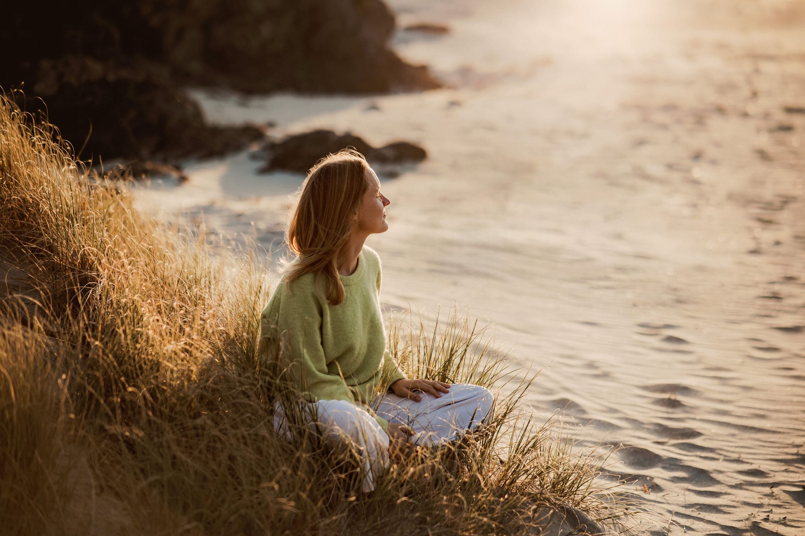 Woman sitting in the sand dunes at sunset lifestyle personal branding